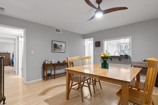 dining space with light wood-type flooring and ceiling fan