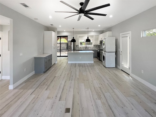 kitchen with stainless steel range oven, ceiling fan, a wealth of natural light, and light hardwood / wood-style flooring