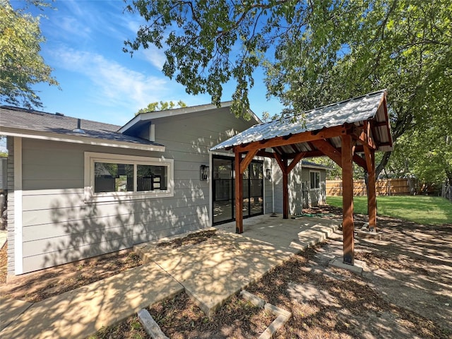 rear view of property with a gazebo, a patio, and a lawn