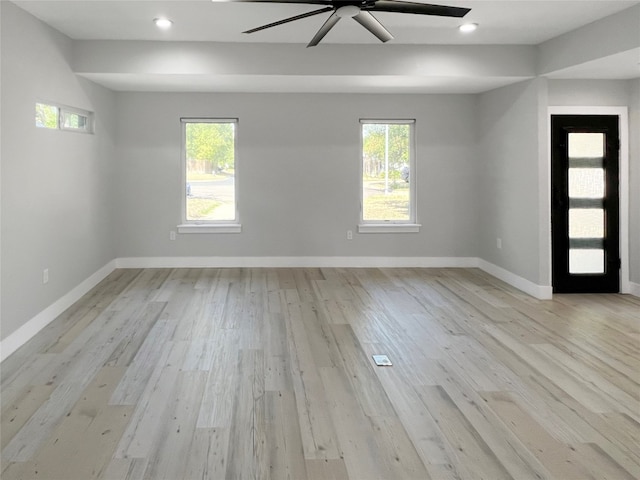 spare room featuring plenty of natural light, ceiling fan, and light wood-type flooring