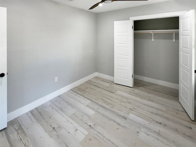 unfurnished bedroom featuring ceiling fan, a closet, and light wood-type flooring