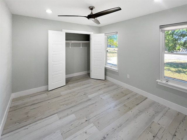 unfurnished bedroom featuring light wood-type flooring, ceiling fan, and a closet