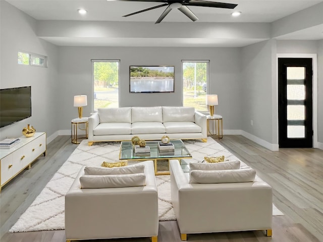 living room featuring light hardwood / wood-style flooring and ceiling fan