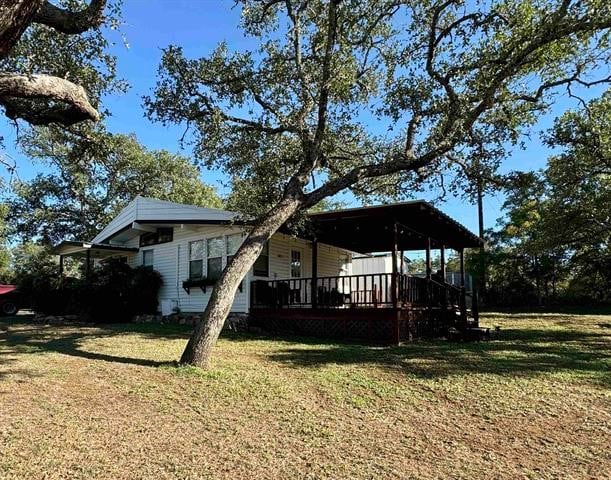 back of property with a lawn and a deck