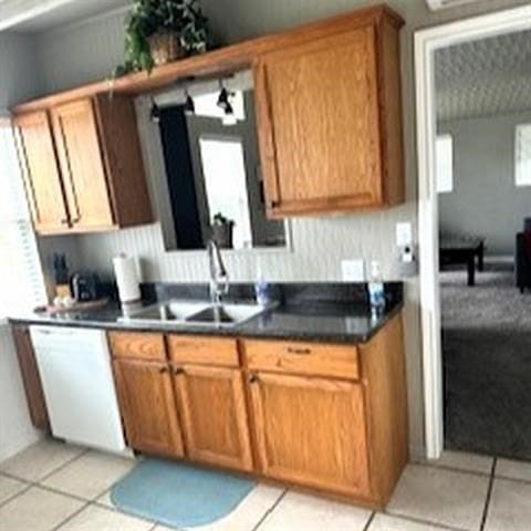 kitchen featuring dishwasher, light tile patterned floors, and sink