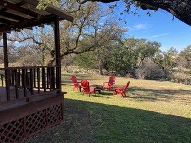 view of yard featuring a wooden deck and an outdoor fire pit