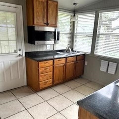 kitchen with light tile patterned floors, hanging light fixtures, and vaulted ceiling