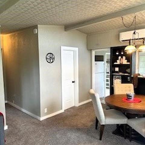 carpeted dining room featuring a wall mounted air conditioner and beam ceiling