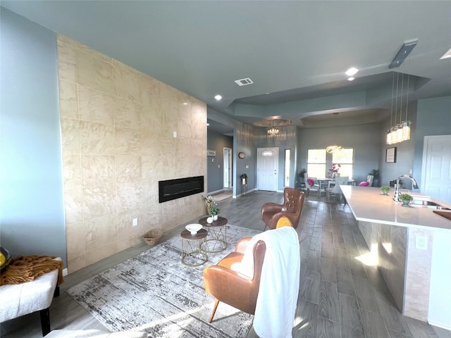 interior space featuring tile walls, a tile fireplace, dark hardwood / wood-style flooring, and sink