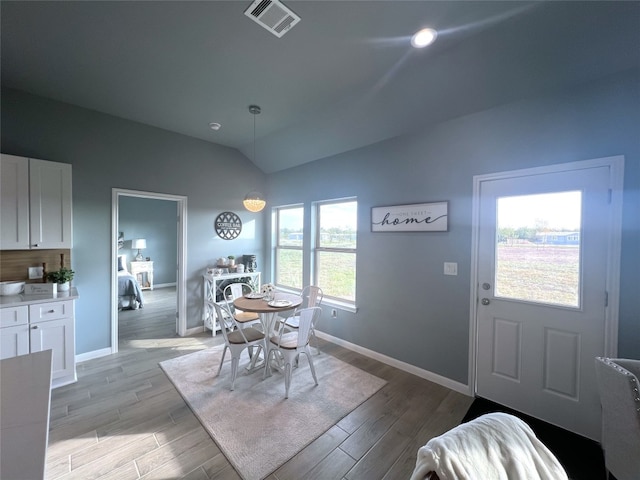 dining space featuring lofted ceiling and light hardwood / wood-style floors