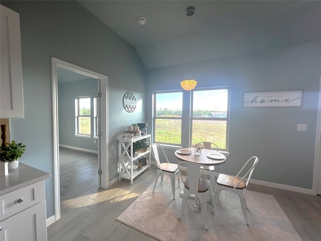 dining room with lofted ceiling and light hardwood / wood-style flooring