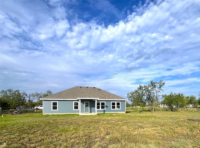 rear view of property featuring a lawn