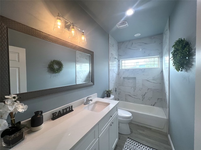 full bathroom with tiled shower / bath combo, vanity, toilet, and hardwood / wood-style flooring