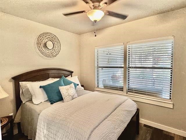 bedroom featuring a textured ceiling, dark hardwood / wood-style floors, and ceiling fan