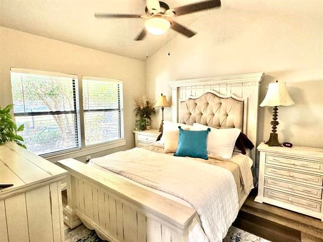 bedroom featuring ceiling fan, dark hardwood / wood-style flooring, and vaulted ceiling