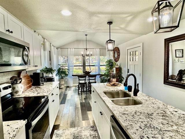 kitchen featuring white cabinetry, sink, stainless steel appliances, and lofted ceiling