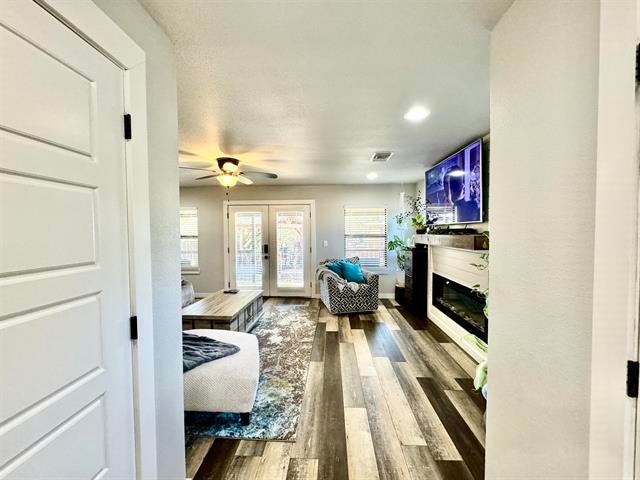 living room with hardwood / wood-style floors, ceiling fan, and french doors