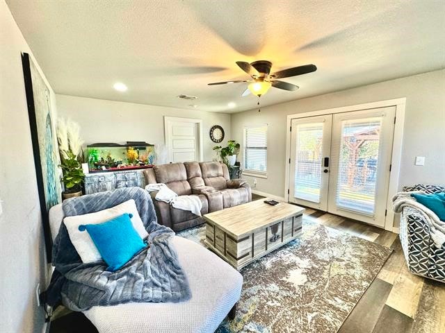 living room featuring wood-type flooring, a textured ceiling, french doors, and ceiling fan