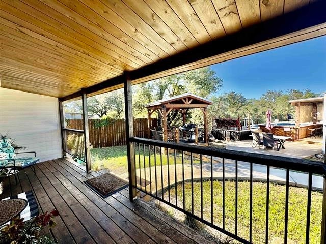 wooden deck featuring a gazebo and a yard