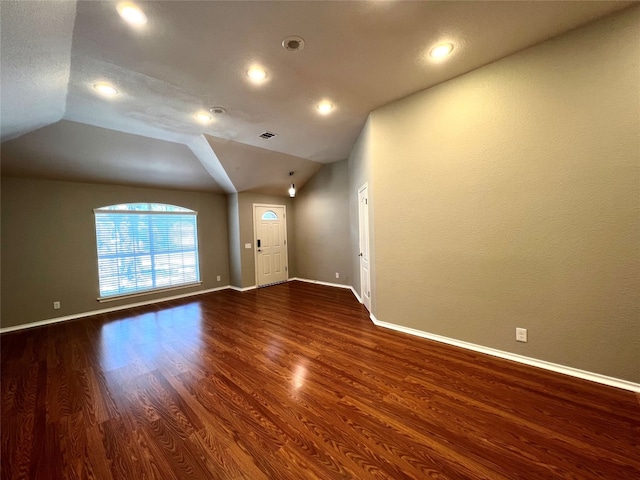 unfurnished room with vaulted ceiling and dark hardwood / wood-style floors