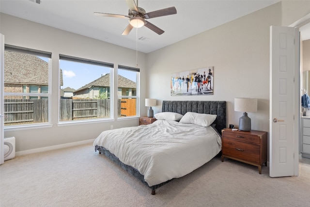 bedroom featuring multiple windows, ceiling fan, and light carpet