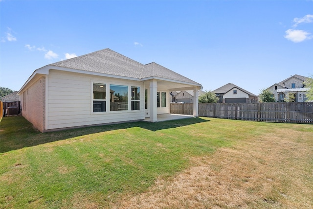 back of house featuring a lawn and a patio