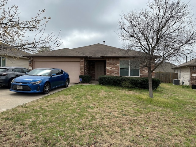 ranch-style home featuring cooling unit, a garage, and a front lawn