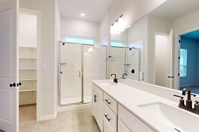 bathroom featuring tile patterned flooring, vanity, and a shower with door