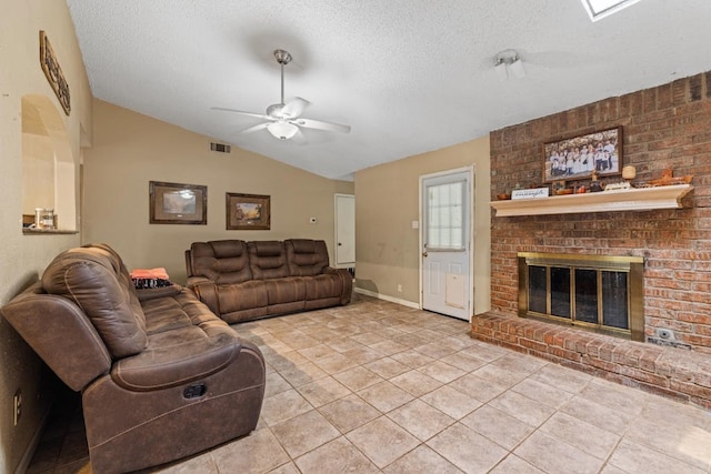 living room featuring a textured ceiling, light tile patterned floors, a brick fireplace, ceiling fan, and lofted ceiling