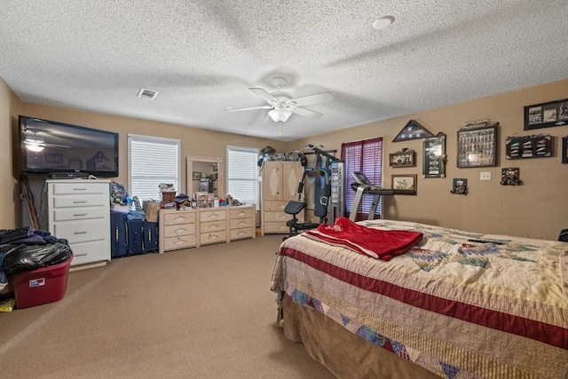 carpeted bedroom with a textured ceiling and ceiling fan