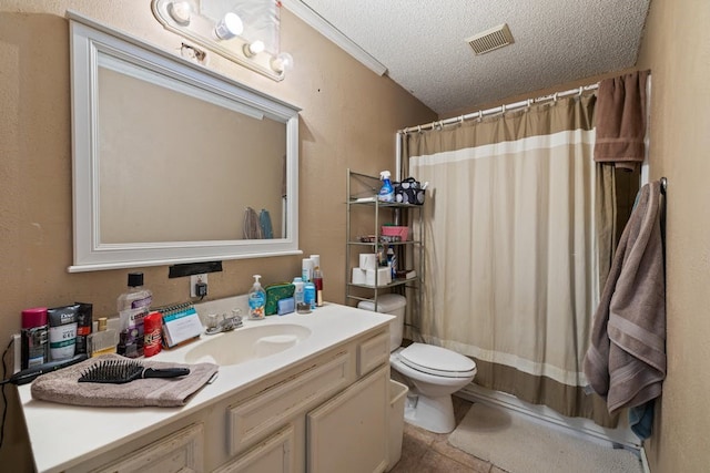 bathroom with tile patterned flooring, toilet, a textured ceiling, and vanity