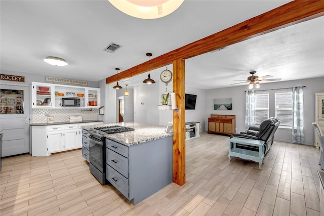 kitchen with white cabinets, light hardwood / wood-style flooring, decorative light fixtures, gas range, and ceiling fan