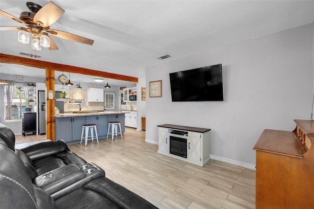 living room with ceiling fan and light hardwood / wood-style floors