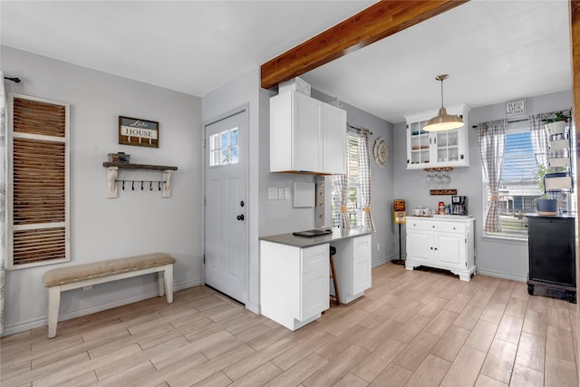 kitchen featuring decorative light fixtures, white cabinetry, and light hardwood / wood-style floors