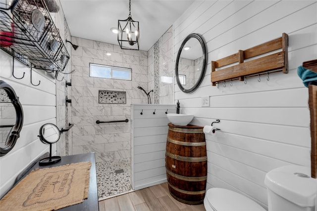 bathroom featuring toilet, a notable chandelier, a shower, wood-type flooring, and vanity