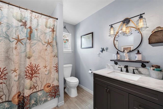 bathroom with a shower with shower curtain, hardwood / wood-style flooring, an inviting chandelier, toilet, and vanity