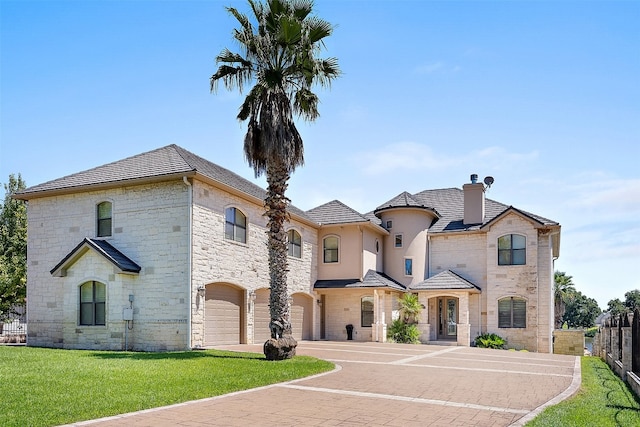 french country style house with a garage and a front yard