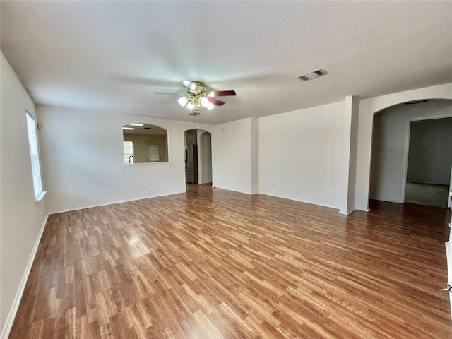 empty room with hardwood / wood-style floors and ceiling fan