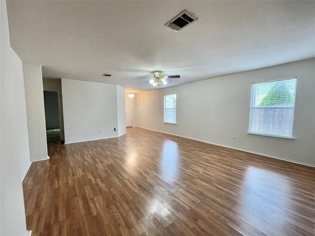 empty room featuring ceiling fan and dark hardwood / wood-style flooring