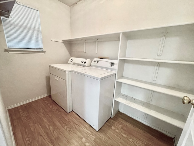 washroom with hardwood / wood-style floors and washing machine and clothes dryer