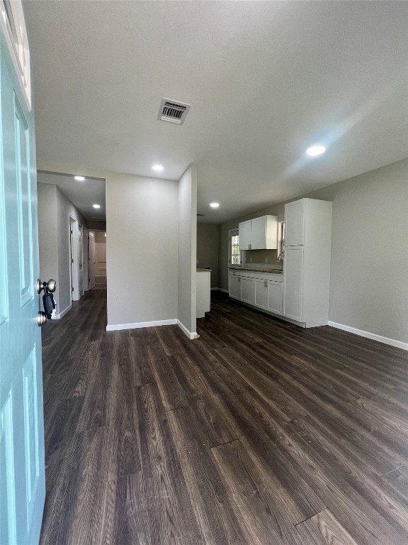 unfurnished living room featuring dark hardwood / wood-style flooring and a textured ceiling