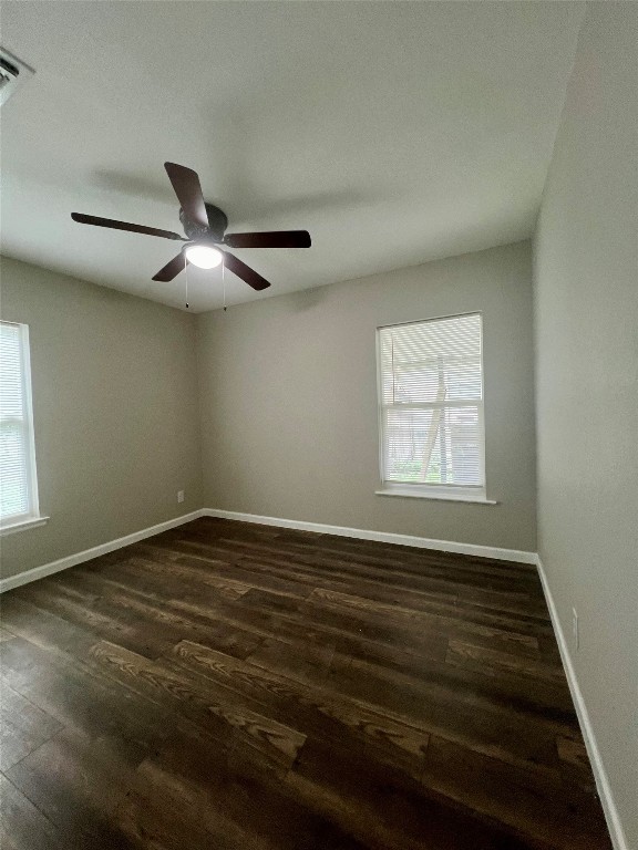 empty room with ceiling fan and dark hardwood / wood-style floors