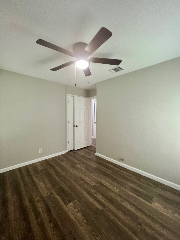 spare room with dark hardwood / wood-style flooring, ceiling fan, and a textured ceiling