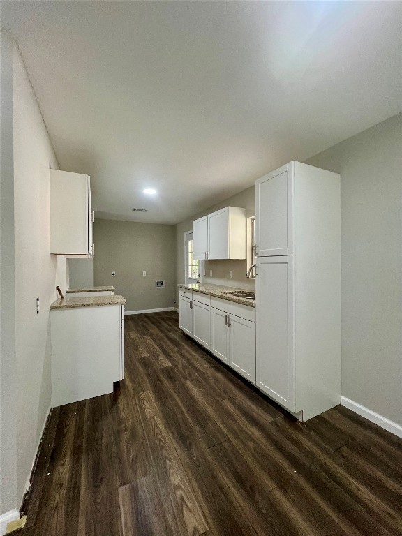 kitchen with white cabinetry, sink, and dark hardwood / wood-style floors