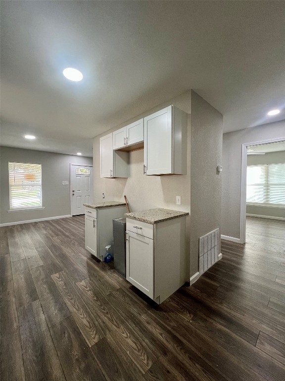 kitchen with dark wood-type flooring and white cabinetry