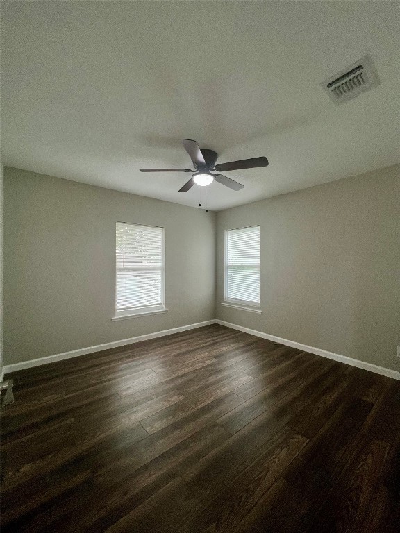 spare room with dark wood-type flooring, a textured ceiling, and ceiling fan