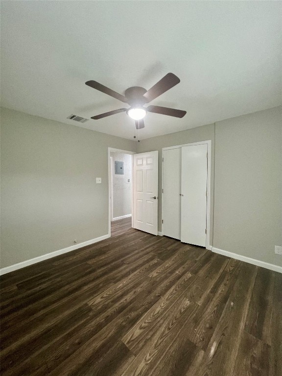 unfurnished bedroom with dark wood-type flooring, a closet, and ceiling fan