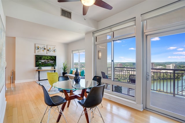dining room featuring plenty of natural light, ceiling fan, visible vents, and light wood-type flooring