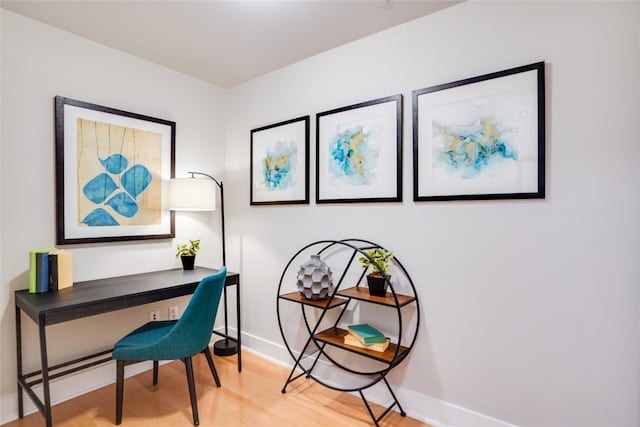 office space featuring baseboards and wood finished floors
