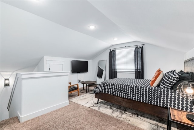 bedroom with carpet floors and vaulted ceiling